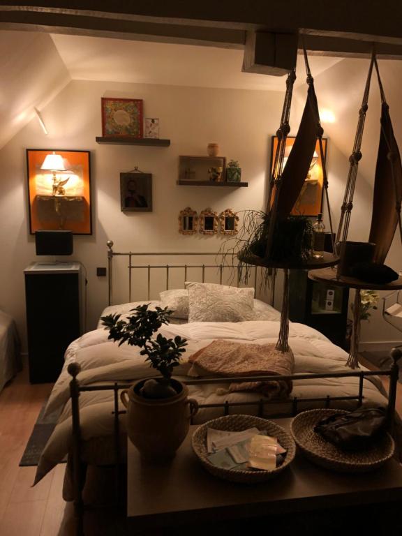 une chambre avec un lit et une table avec une plante dans l'établissement La Thibautière, à Blaison-Gohier