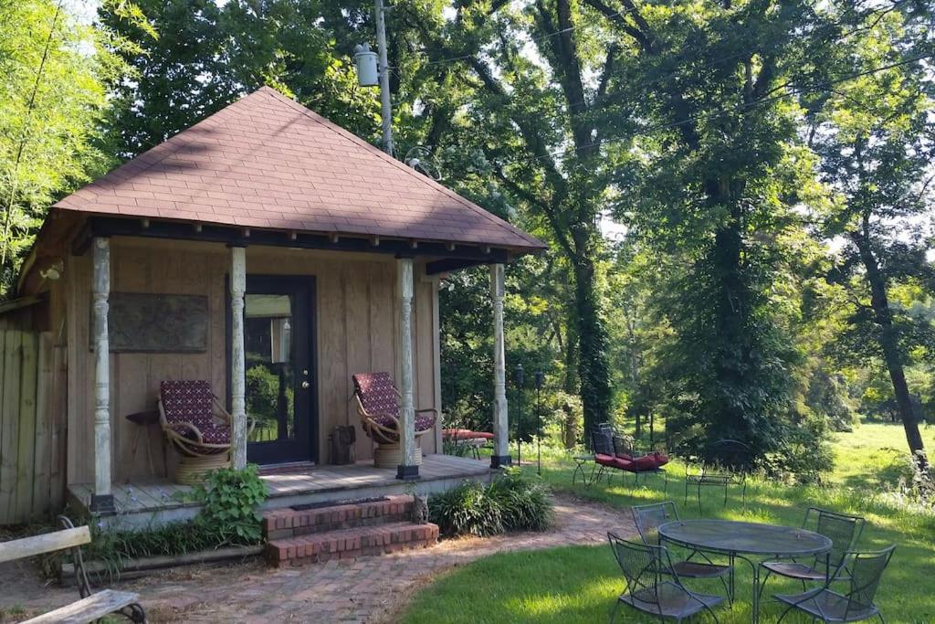 a gazebo with a table and chairs in a yard at Sunflower Cottage on the River in Clarksdale