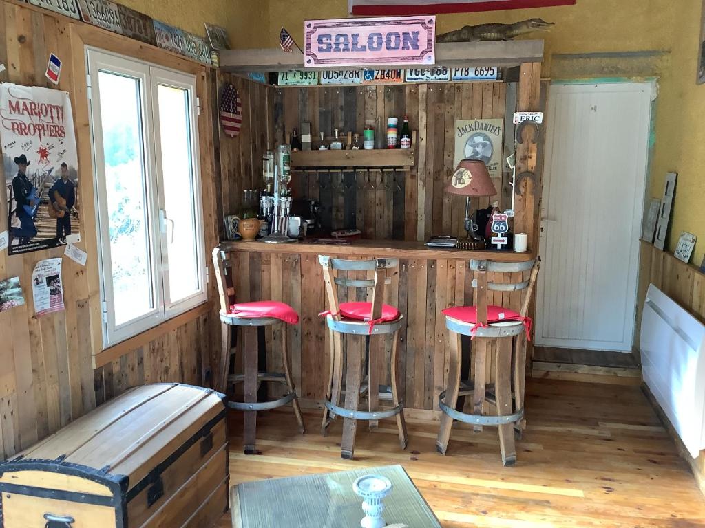 un bar avec quatre tabourets dans une pièce dans l'établissement Villa au calme, à Vidauban
