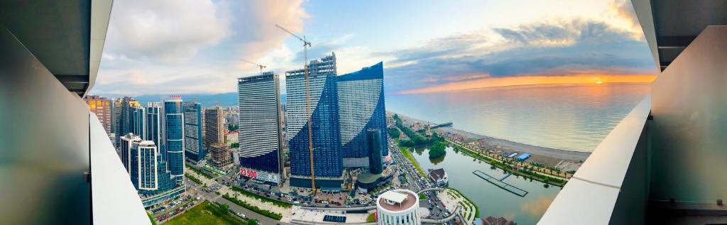 a picture of a city with skyscrapers and the water at Apartment in Alliance palace on the Justice side in Batumi