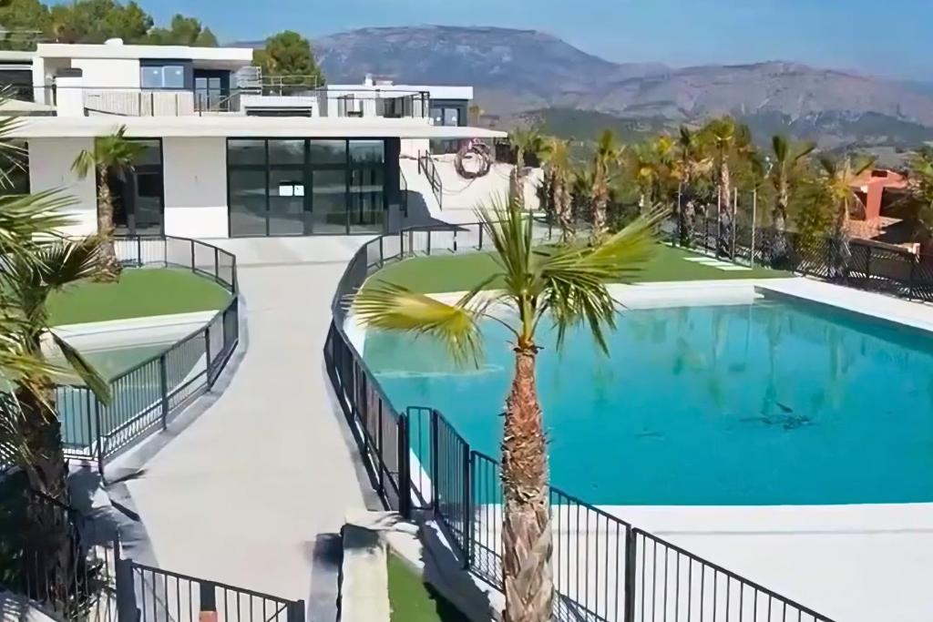 a view of a house with a swimming pool and a palm tree at Villa SolyMar in Polop Hills Luxury and comfort ! in Polop