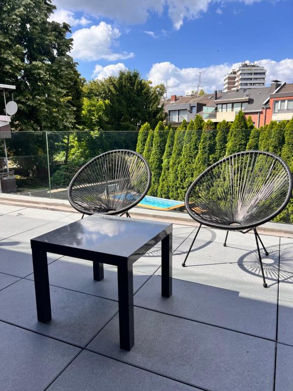two metal chairs and a table on a sidewalk at Neubau Luxus 2 Zimmer Apartment in Mönchengladbach