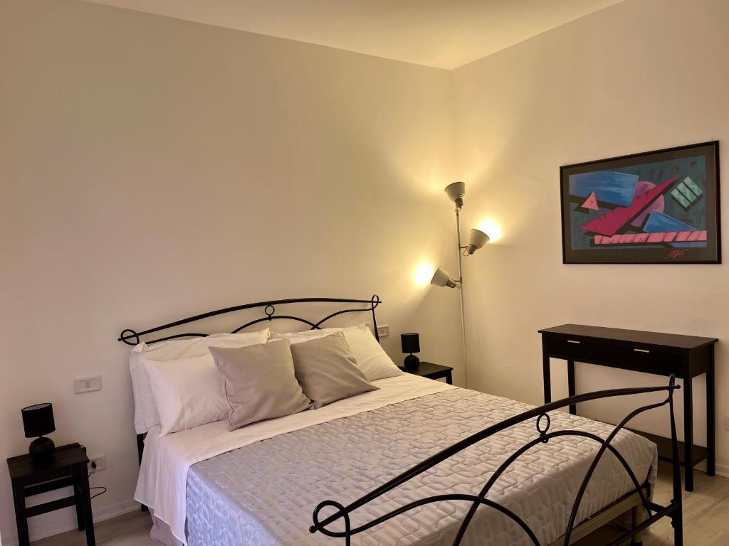 a bedroom with a bed and a lamp and a picture at Lake & Nature Apartment in Ispra