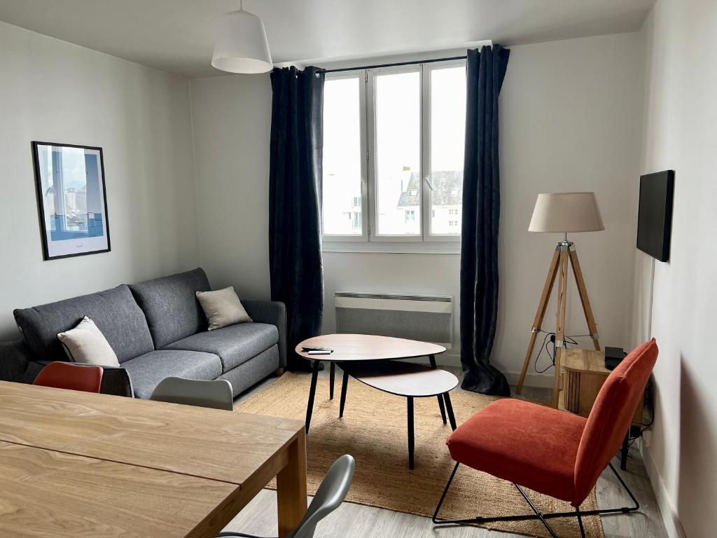 a living room with a couch and a table at Appartsaintnazaire - Saint Nazaire - 5 Appartements - Centre Ville in Saint-Nazaire