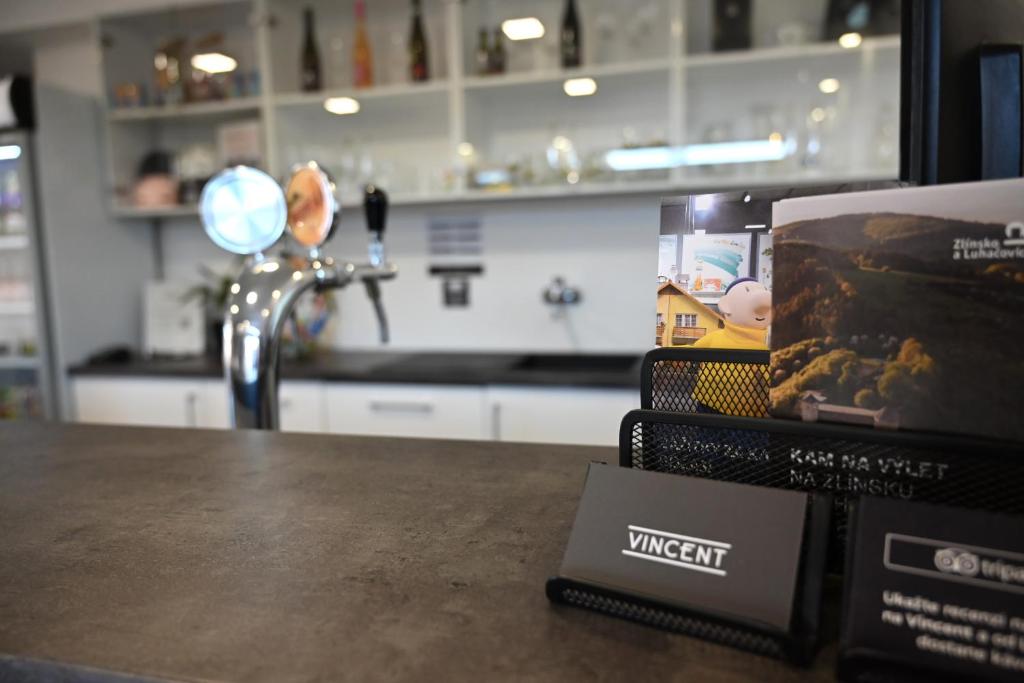 a book sitting on a table next to a kitchen at Hotel Vincent in Luhačovice