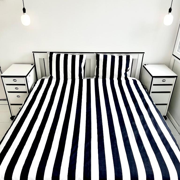 a bedroom with a bed with black and white stripes at 2D Apartment in Szekszárd