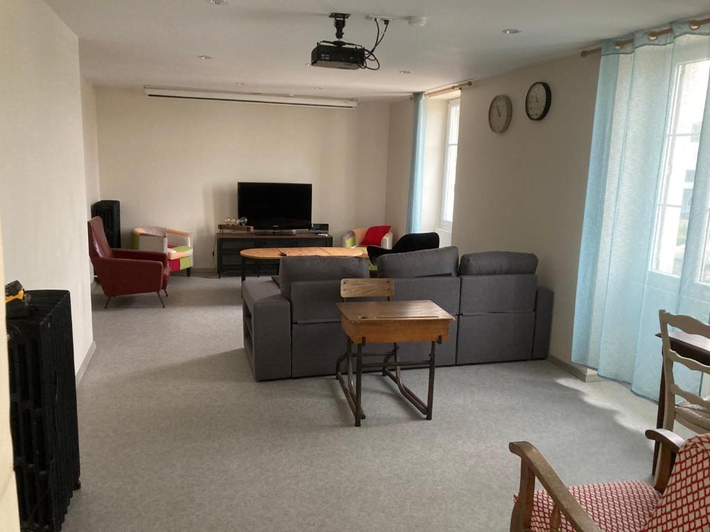 ein Wohnzimmer mit Sofa und Tisch in der Unterkunft Appartement Hôtel de la Gare 3 chambres in Château-du-Loir