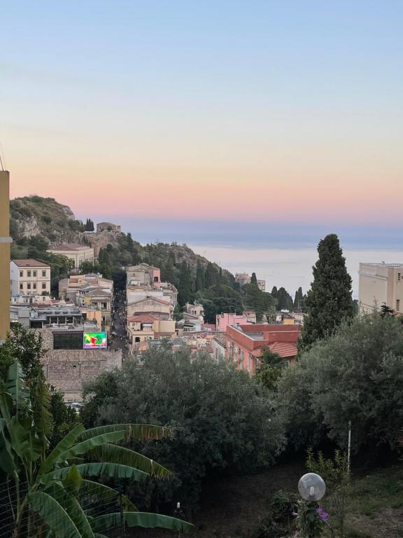 a view of a city from a hill at sunset at Villa des Arts - Taormina in Taormina