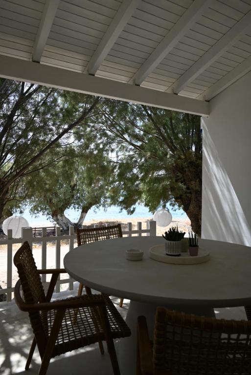 een tafel en stoelen op een patio met uitzicht op de oceaan bij Kythnos Seaside House Flampouria in Kithnos