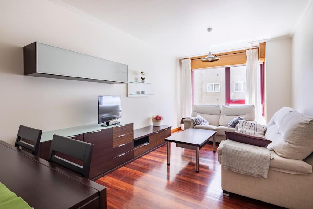salon z kanapą i stołem w obiekcie Apartamento Lua w mieście Milladoiro