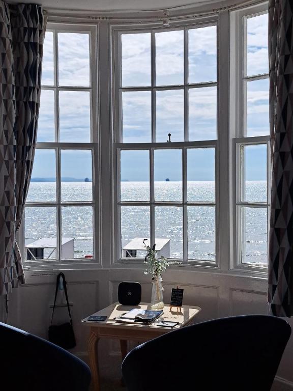 a room with a table and a large window with a view at Lyndale Guest House in Weymouth