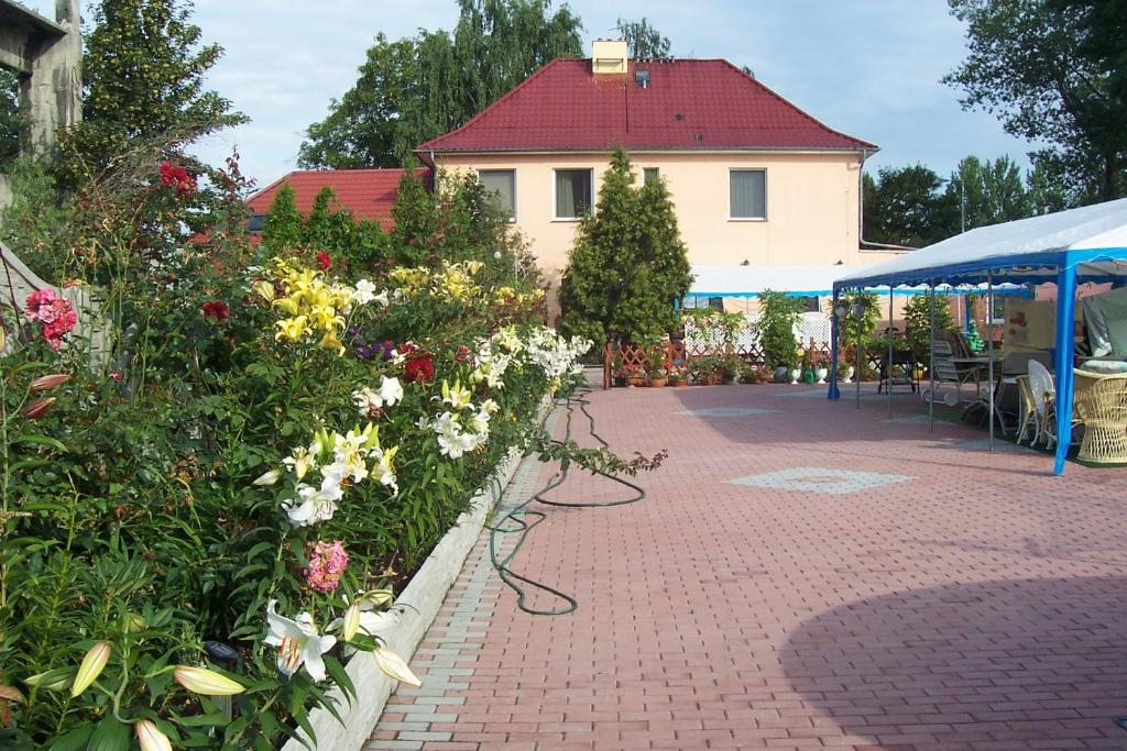 einen Backsteinsteg mit Blumen vor einem Gebäude in der Unterkunft Zajazd Mieszko in Oppeln