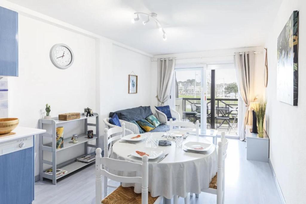 a kitchen and living room with a white table and chairs at Résidence La Commanderie - maeva Home - Appartement vue sur le port 2 pièces 4 personnes - Sélection - super Home MAE-7721 in Arzon