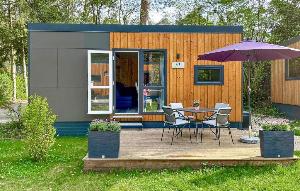 ein kleiner Schuppen mit Tisch und Stühlen und einem Sonnenschirm in der Unterkunft Tiny Haus 61 Am Brombachsee in Pleinfeld