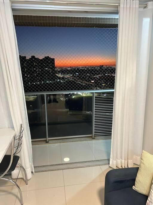 a room with a window with a view of a city at Pôr do Sol DF Plaza in Brasília