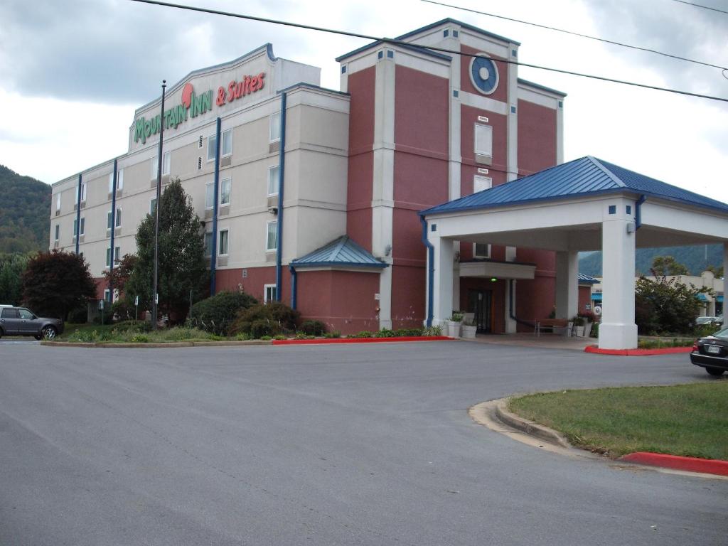 a large red and white building with a gas station at Mountain Inn & Suites in Erwin