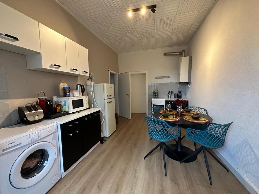 a kitchen with a washing machine and a table with chairs at Central appartment 2zimmer Waschmaschine trockener in Duisburg