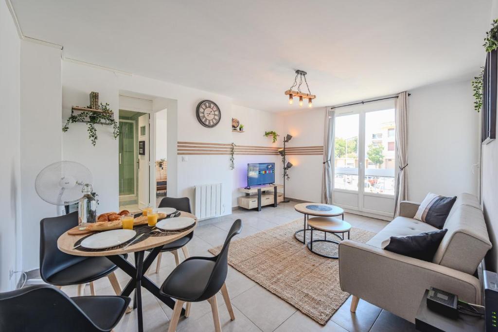 un salon avec une table, des chaises et un canapé dans l'établissement Appartement Port Marchand, à Toulon