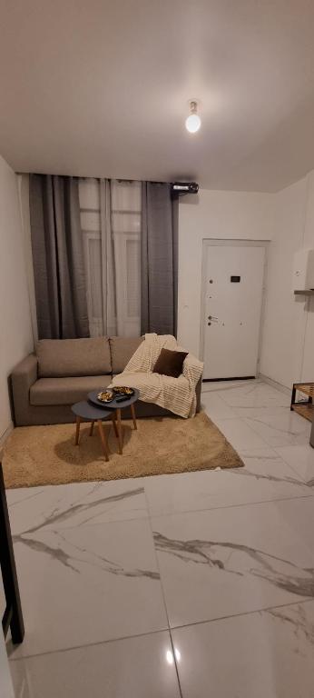 a living room with a couch and a table at Lecomte studio in Oissel