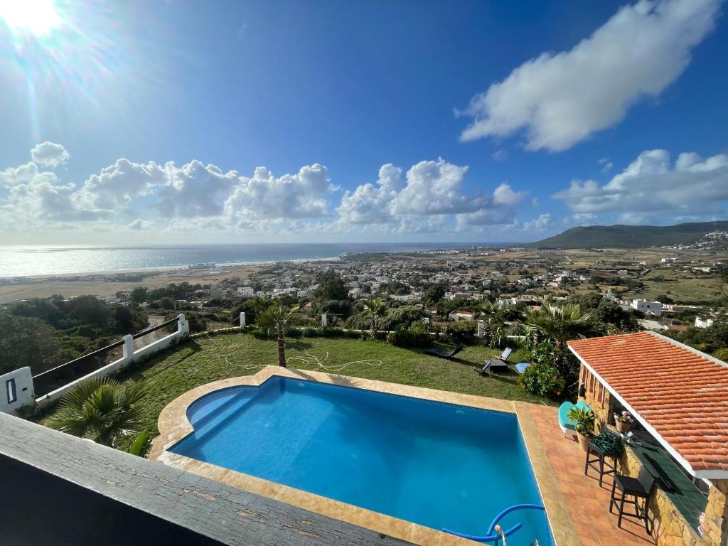 a villa with a swimming pool and a view of the ocean at Villa Casa Deraoui in Tangier