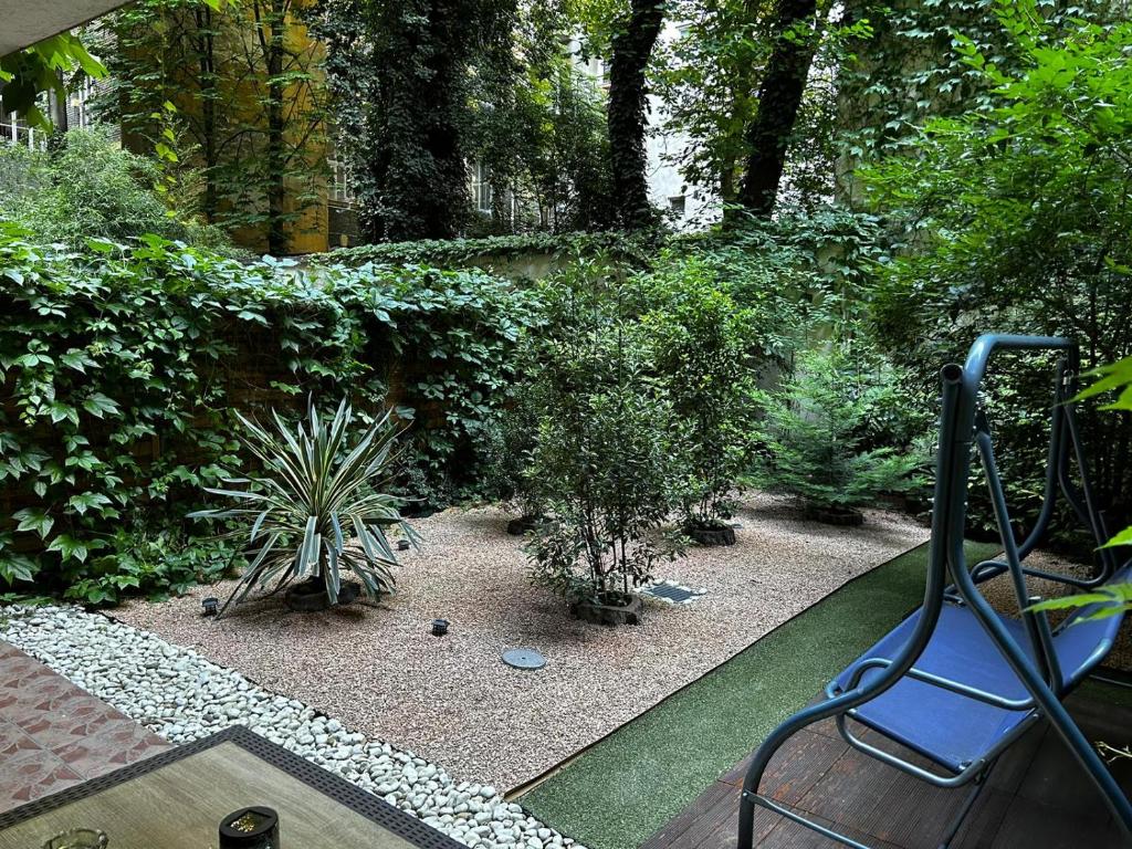 a garden with a bench and some plants and trees at Exclusive Central Apartment with Private Garden in Budapest