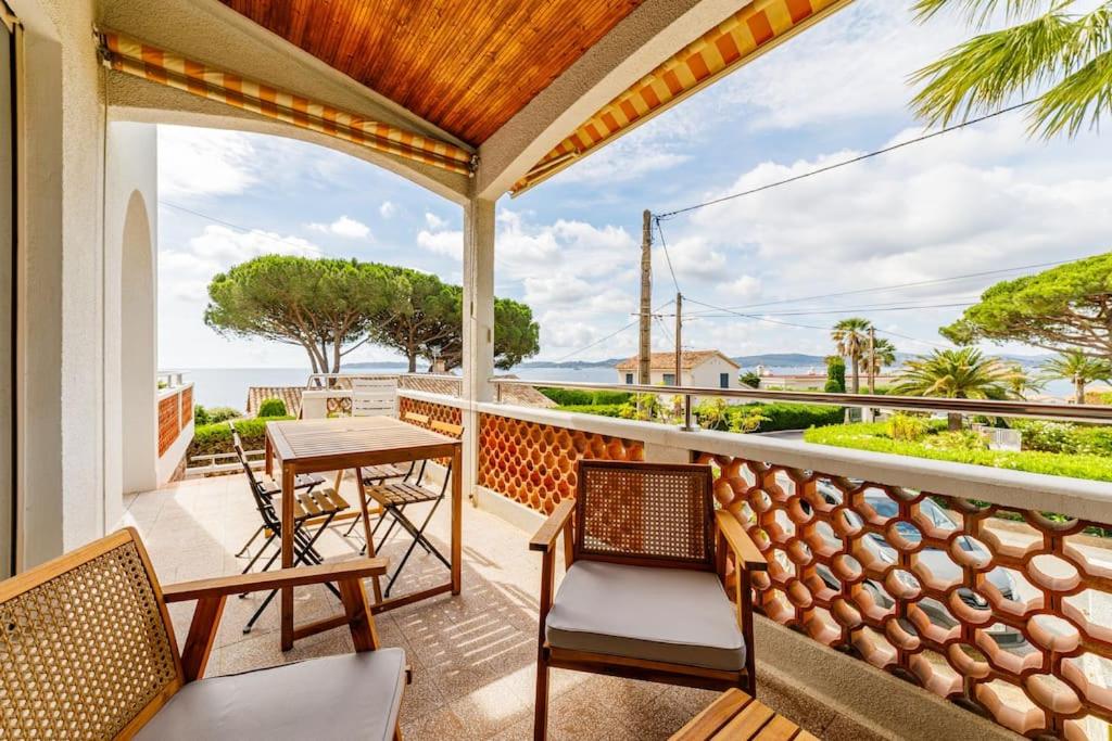 un balcon avec une table et des chaises et l'océan dans l'établissement Haut de villa, vue sur mer à Sainte-Maxime, à Sainte-Maxime