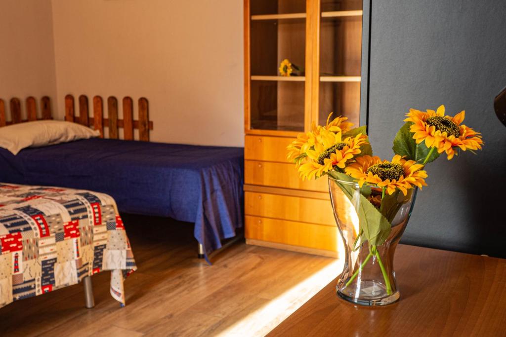 a vase of sunflowers sitting on a table in a bedroom at I Girasoli Holiday Home in Pompei