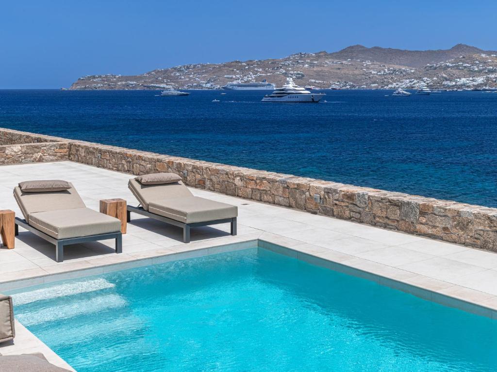 basen z dwoma krzesłami i ocean w obiekcie Star villa by Bestofmikonos w mieście Mykonos
