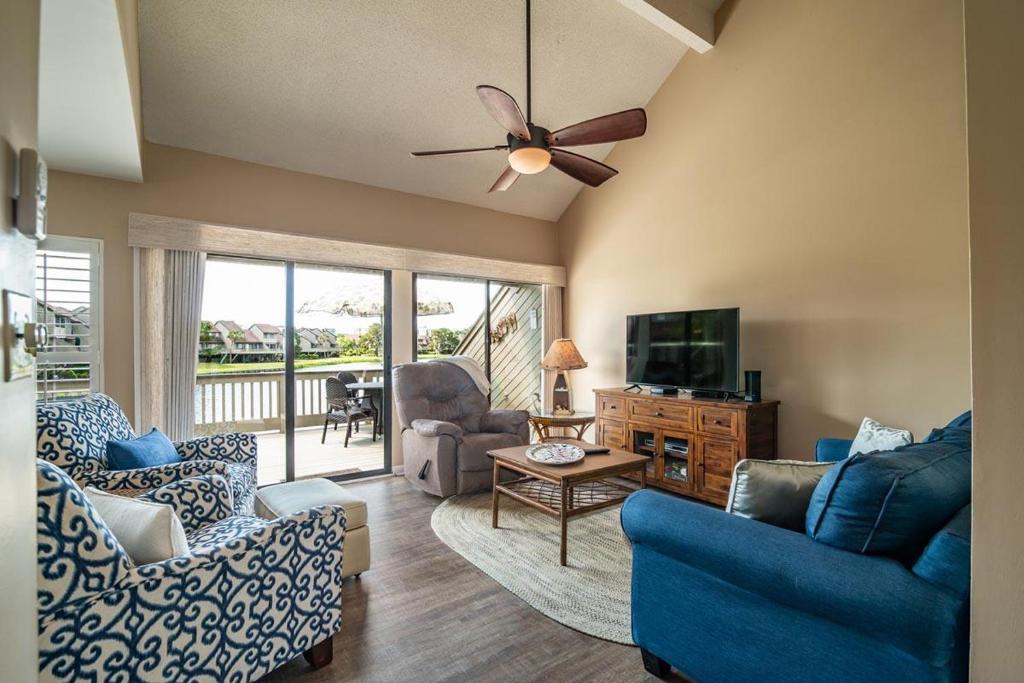 a living room with blue furniture and a ceiling fan at Serene Lakeview Retreat 3BR Villa Beach Access in Pawleys Island