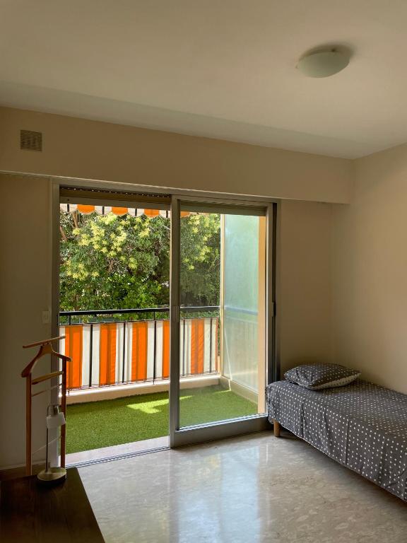 - une chambre avec un lit et une grande porte coulissante en verre dans l'établissement GuestRoom - Chambre d'hôte, au Cannet