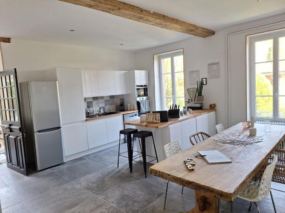 une cuisine avec une table en bois et un réfrigérateur dans l'établissement Maison chaleureuse Marsannay la Cote, à Marsannay-la-Côte