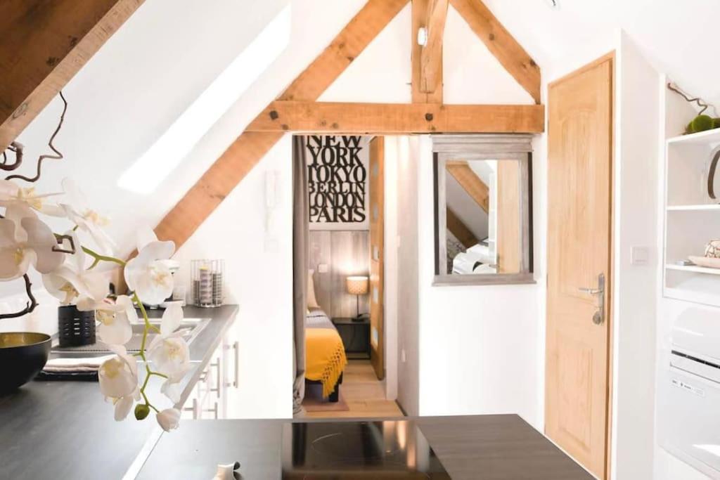 a kitchen with white walls and wooden beams at ADORABLE PETIT LOFT CLIM WIFI au pied de la cité in Sarlat-la-Canéda