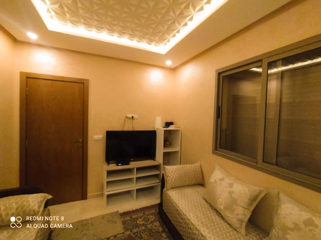 a living room with a couch and a flat screen tv at Appartement à Bouznika prêt du plage Dahomey, plage bouznika, Bahia beach in Bouznika