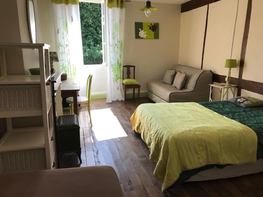 une chambre avec un lit et un canapé dans l'établissement MAISON entre CREUSE et BERRY, à Badecon-le-Pin