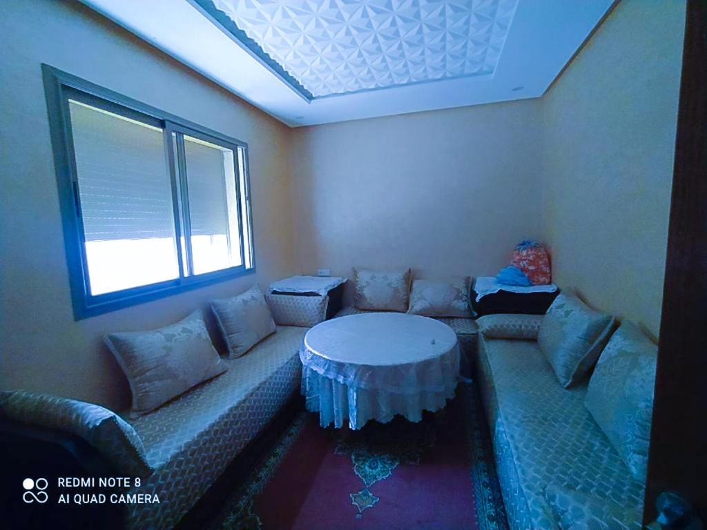 a living room with a couch and a table at Appartement à Bouznika prêt du plage Dahomey, plage bouznika, Bahia beach in Bouznika