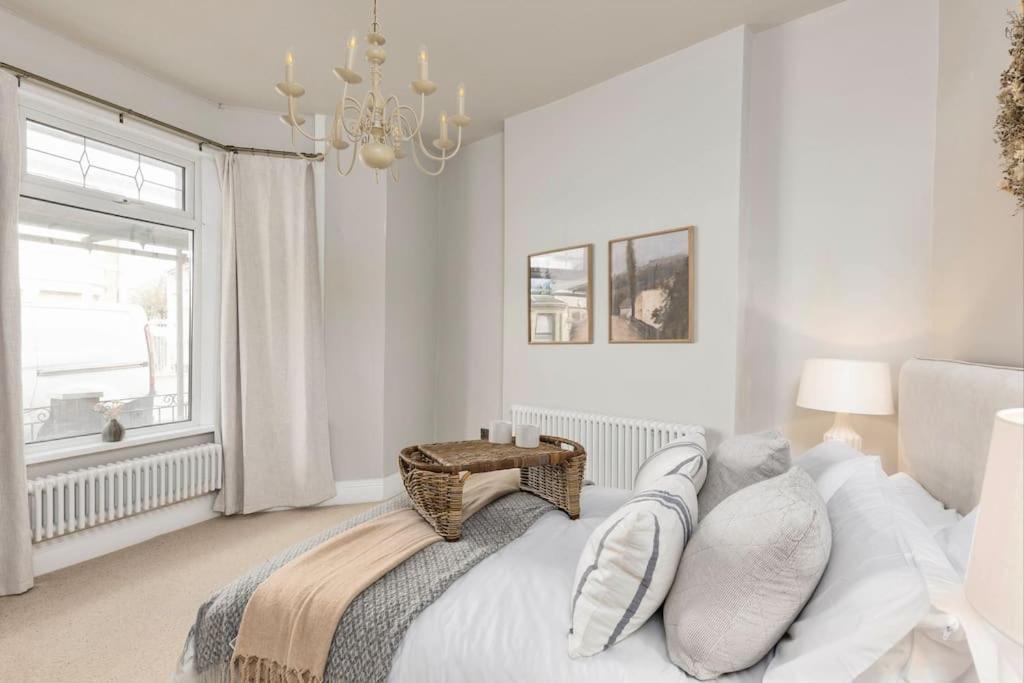ein weißes Schlafzimmer mit einem Bett und einem Fenster in der Unterkunft Luxury Townhouse in Cardiff City Centre, 5 bedrooms, up to 12 guests in Cardiff