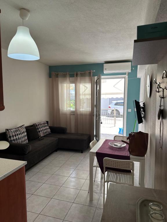 a living room with a couch and a table at La kaza studio in Ofrínion