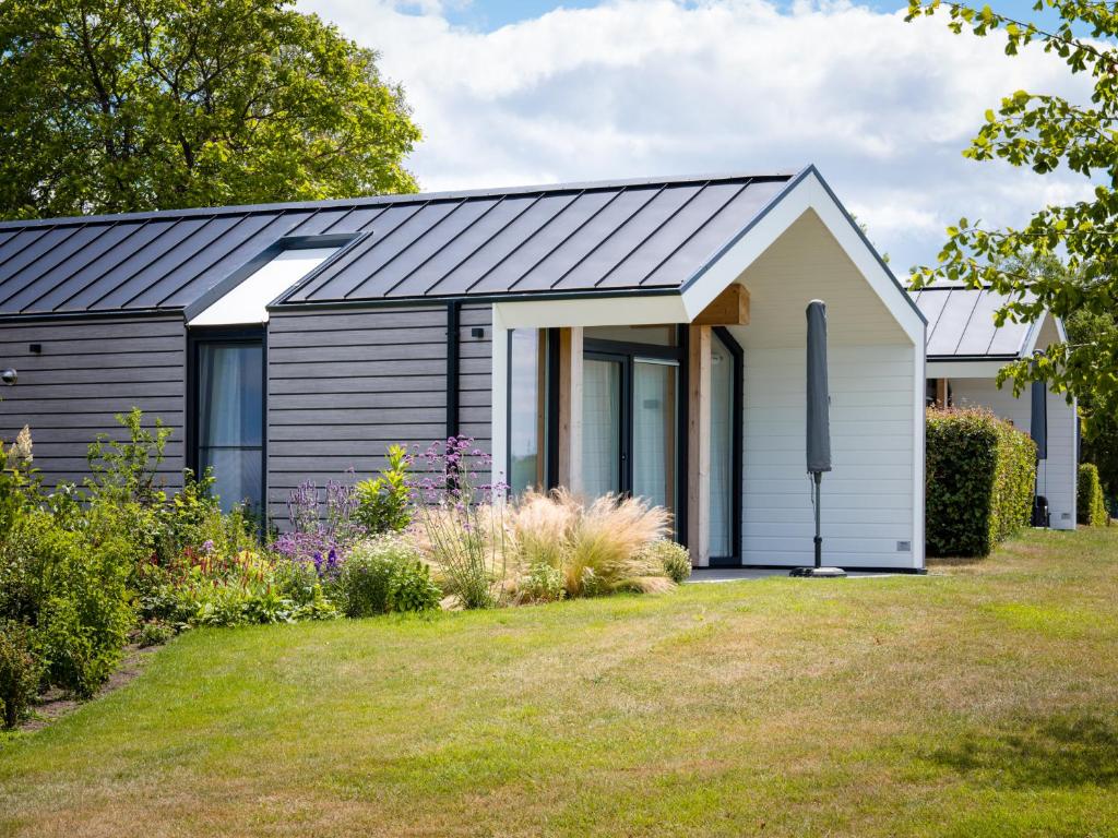 a house with a metal roof on a yard at Eco Holiday Home - Airco & Panoramisch uitzicht - Achterhoek in Almen