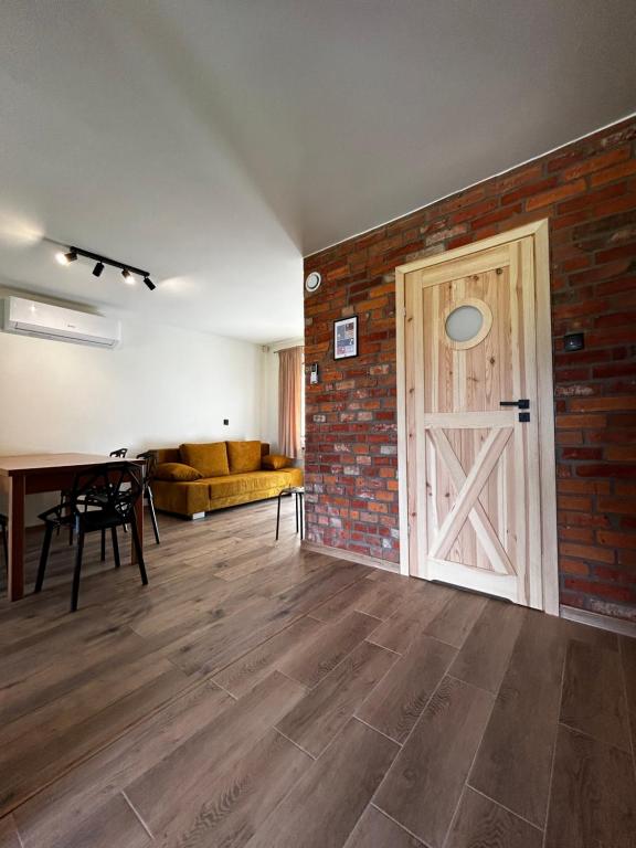a room with a brick wall and a door at Słona Fala in Sianozety