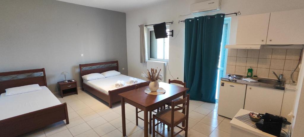 a room with a bed and a table and a kitchen at KANALI HOLIDAYS APARTMENT 4 in Kanali