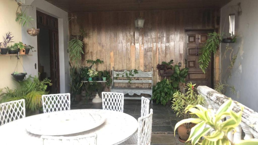 a patio with a table and chairs and a bench at Casa Amarela in Belo Horizonte