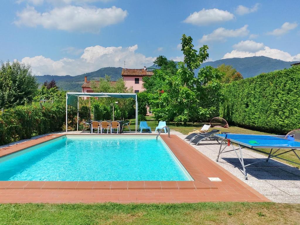 a swimming pool with a table and chairs in a yard at Villa Cortinella in Marlia