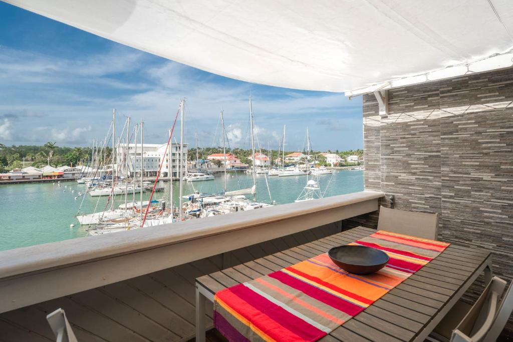 a table and chairs on a balcony with a marina at Appartement Honoré in Saint-François