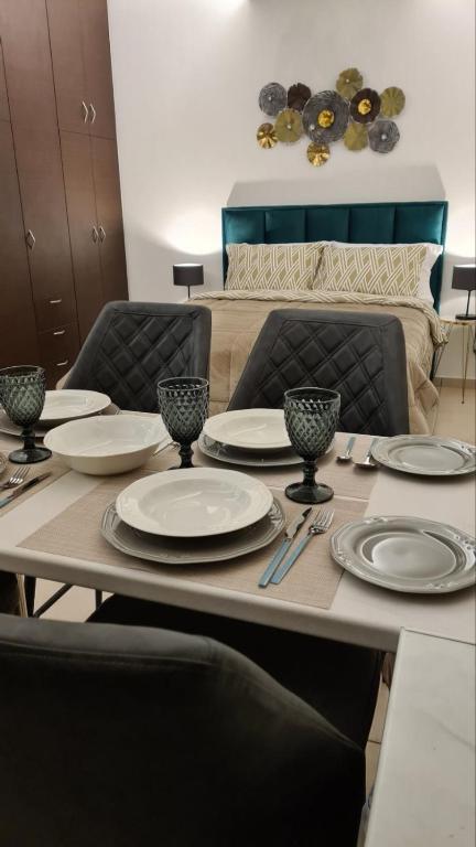 a dining room table with plates and utensils on it at Διαμερίσματα CANNA in Samos