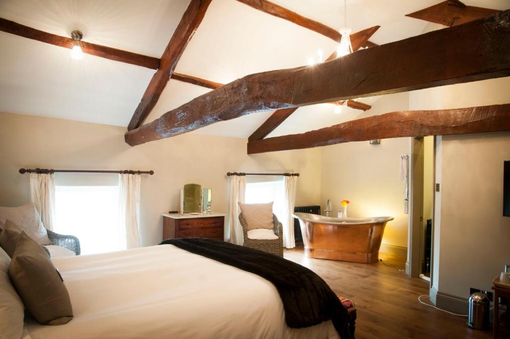 a bedroom with a bed and a desk and a tub at The Priory in Middleham