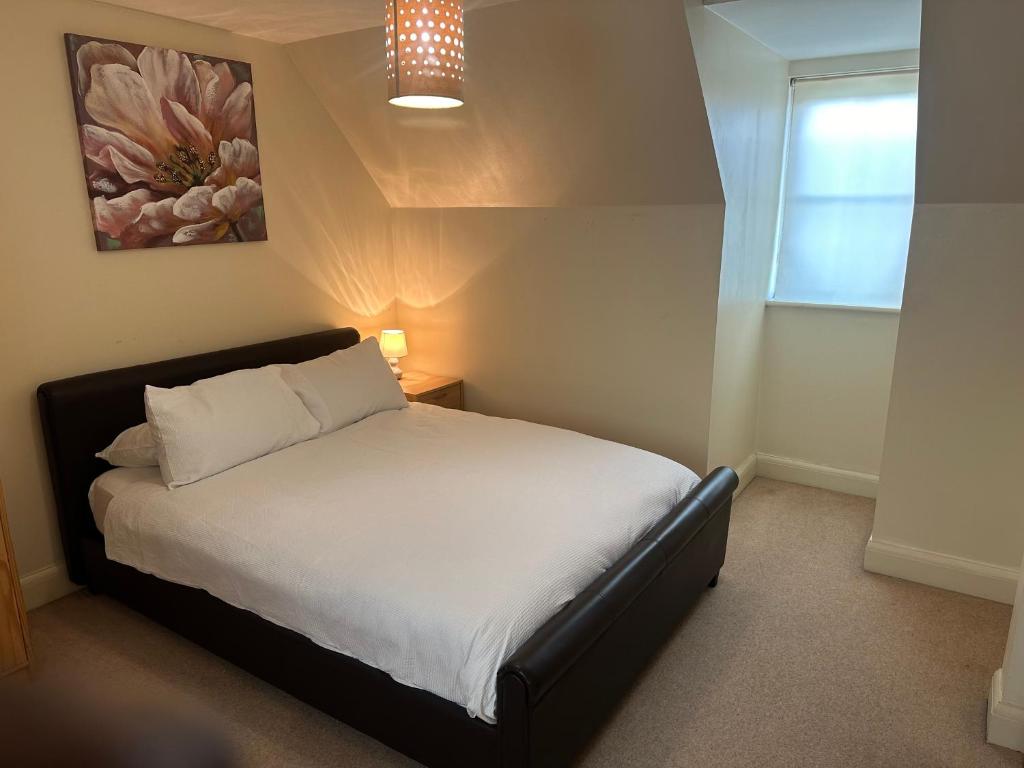 a bedroom with a white bed with a painting on the wall at Comfort Arena in Colchester