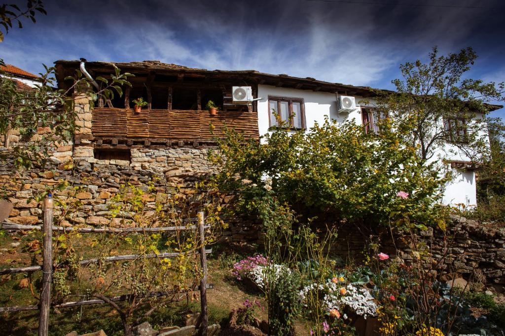 a house with a stone wall and a garden at Porodična kuća Vitina Iža in Pirot
