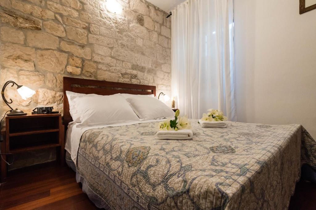 um quarto com uma cama e uma parede de pedra em Villa Sv. Petar em Trogir