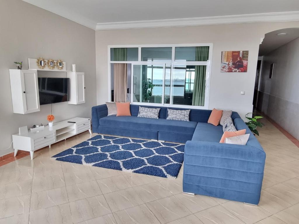a living room with a blue couch and a blue rug at Beach View Apartment (Boulevard Mohammed VI) in Tangier