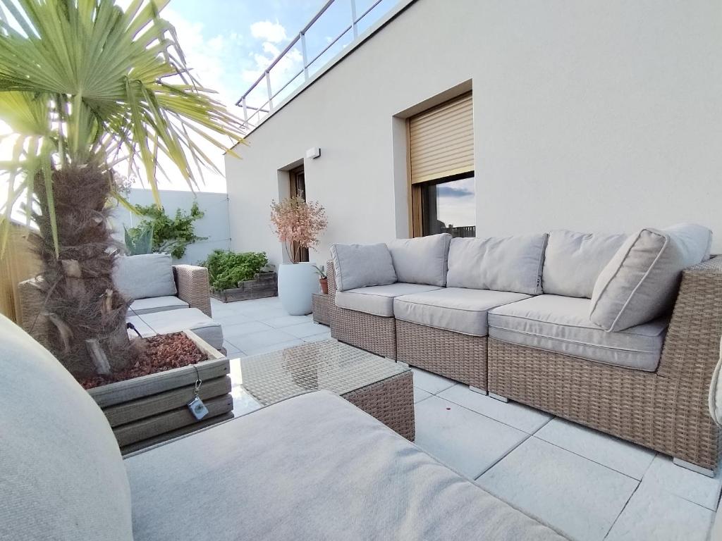 - un salon avec un canapé et un palmier dans l'établissement Penthouse terraces 4 rooms, à Fontenay-sous-Bois